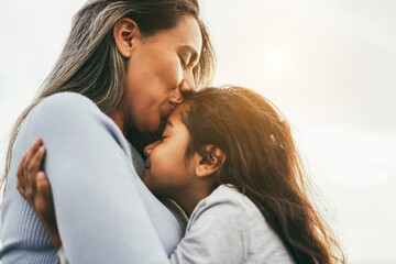 Happy latin mother and daughter having tender moment together outdoor - Mom day and love concept -...