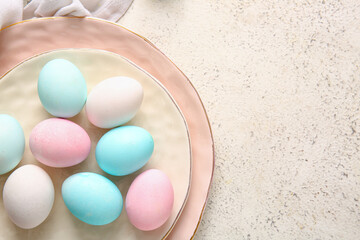 Plate of painted Easter eggs on light background, closeup