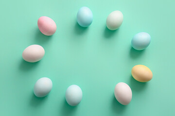 Frame made of natural and painted Easter eggs on color background