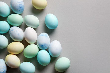 Many painted Easter eggs on grey background
