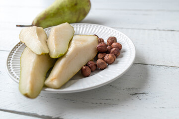 Healthy natural energy snack with fresh pears and hazelnuts isolated on white background with copy space