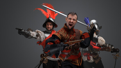 Portrait of isolated on grey background conquistador with rifle and soldier pointing finger.
