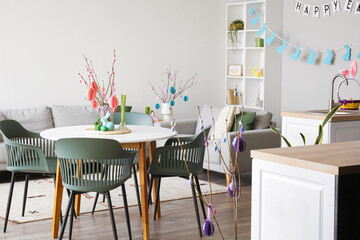 Interior of kitchen with tree branches, Easter eggs and dining table