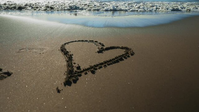 Heart drawn on the sandy sea beach.