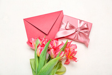 Beautiful tulip flowers, envelope and gift for Women's Day celebration on white background
