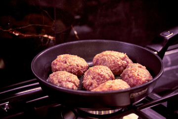 meat cutlets are fried in a frying pan in the kitchen