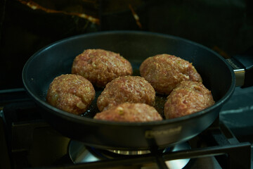 meat cutlets are fried in a frying pan in the kitchen