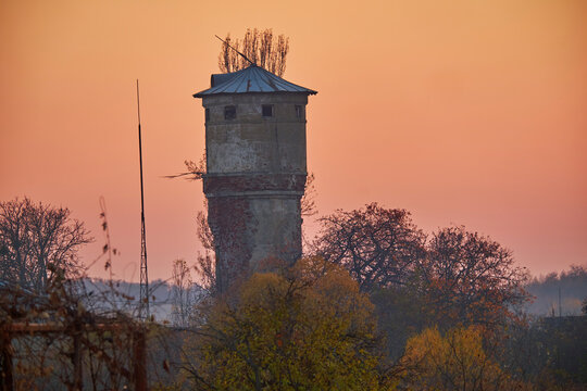 Old brick tower with a broken lightning rod on an autumn evening