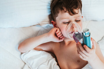 child with inhaler in bed - obrazy, fototapety, plakaty