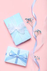 Composition with gift boxes, ribbon and gypsophila flowers on pink background. Women's Day celebration