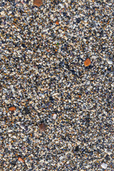 Beautiful horizontal texture of yellow sand with waves pebbles and shells is in the photo