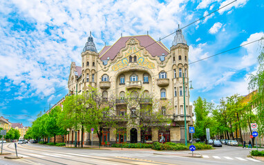 Fototapeta premium Front view the facade of beautiful old building with old sculptures in the city center of Szeged, Hungary 