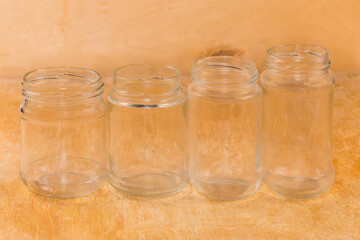 Fototapeta na wymiar Empty glass jars different sizes on a wooden surface