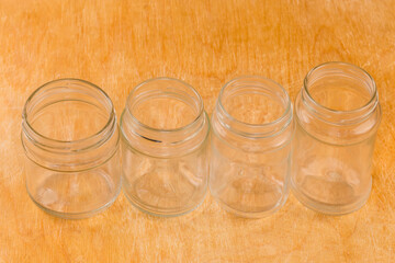 Empty small glass jars different sizes on a wooden surface