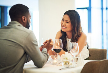 Wine, date and interracial couple holding hands for fine dining, restaurant or valentines celebration together. Black man, asian woman and alcohol glasses for romance, wealth or luxury anniversary