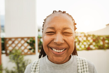 Senior african woman smiling on camera outdoor - Main focus on nose