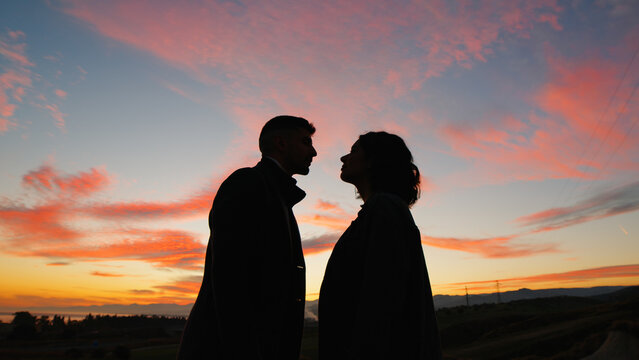 Silhouette of couple kiss against the orange sunset