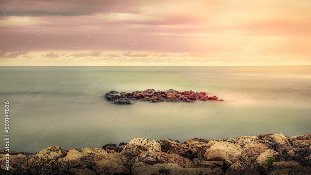 Wall mural sea rocks landscape in stunning colored sky