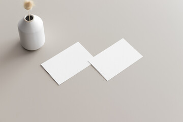 Two white business cards mockup with a lagurus on the beige table. 5x7 ratio, similar to A6, A5.