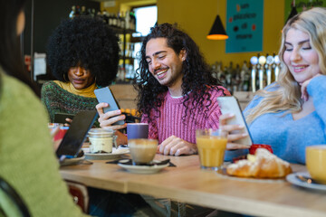 The Content Creators Breakfast, young long-haired guy uses his smart phone device to share content online, people who photograph food and use social networks