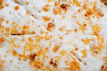 Close-up of fresh cheese pizza with mozzarella, cheddar and parmesan. Top view texture food italian cuisine