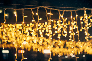 Yellow lights bokeh from christmas holiday garlands, blurred festive background, abstract lights