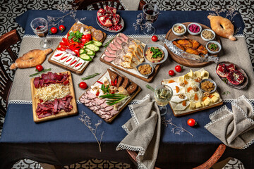 Food Table Celebration Delicious Party Meal Concept. A lot of food on the table: khachapuri, manti, lamb, beef, basturma, satsivi, pkhali, dolm.   Foodset from Georgian dishes. Caucasian food