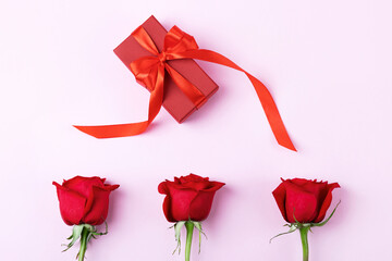 Happy Valentine's Day, Mother's Day and birthday greeting card. Red roses and gift box with a satin ribbon bow