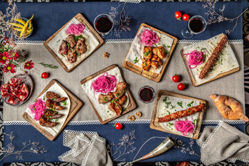 Food Table Celebration Delicious Party Meal Concept. A lot of food on the wooden table. Different types of grilled meat and fish. Shish kebab from pork, beef, lamb, chicken.