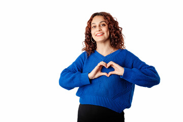 Cute millennial woman wearing sweater standing isolated over white background making a heart gesture with her fingers in front of her chest showing her love. With love, you are not alone. I love you.