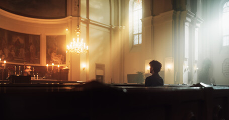 A Devout Christian Sits Piously In A Grand Church, Folding Hands for Praying, Contemplating Their...