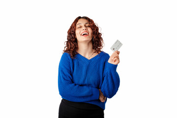 Happy woman wearing blue knitted sweater standing isolated over white background laughing and holding credit or bank card. Showing teeth.