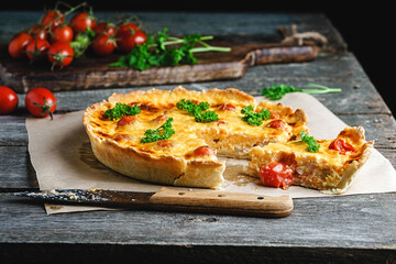 Quiche lauren - cheese vegetable pie with chicken on a wooden table	