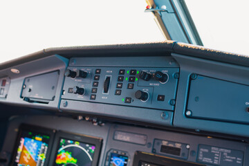 Close-up cockpit view of aircraft control panel in flight at sunset