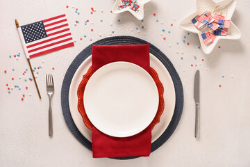 Patriotic table setting with american flag and decoration in national flag colors on white background. Independence Day. Happy Memorial Day. View from above. Copy space.