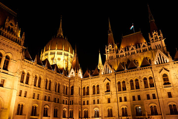 Fototapeta premium Evening photo of the Parliament building in Budapest.The majestic Saxon architecture is illuminated with warm yellow light