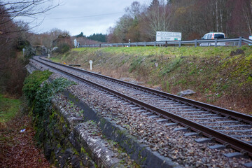 Empty train track parallel to road with van driving