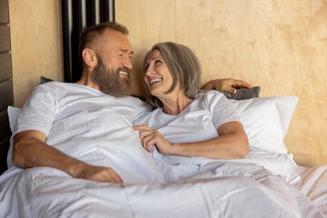 Obraz na płótnie Canvas Mature couple staying in bed and looking happy