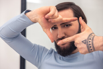Man with the madeup lashes showing a hand gesture