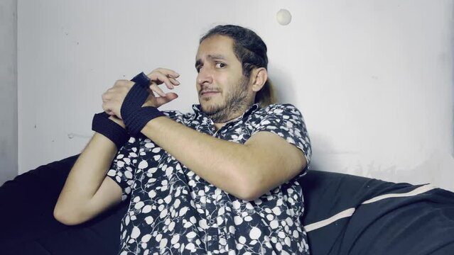 stressed man trying to free his bound hands from the belt