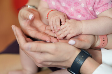 hands of parents and baby girl newborn