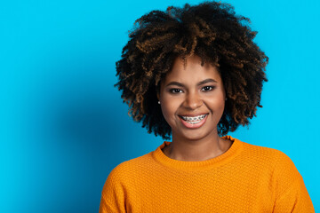 Portrait of attractive smiling black woman posing on blue