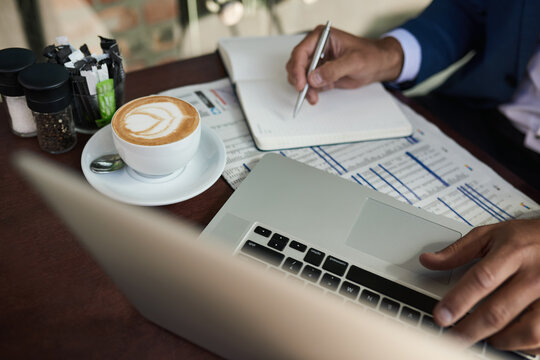 Businessman working over coffee outside at a cafe table