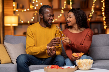 Cheery black spouses celebrating weekend at home, have dinner