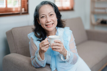 Portrait of an elderly Asian woman drinking tea for health.