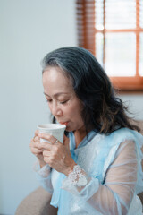 Portrait of an elderly Asian woman drinking tea for health.