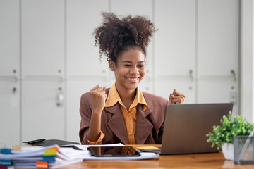 Smiling businesswoman celebrating success in an office.