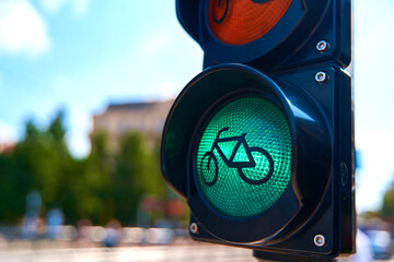 Close-up of a traffic light for cyclists, which is glowing green. A bicycle is shown on the traffic...