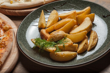 Two different pizzas on the boards and fried potatoes in a plate on the table