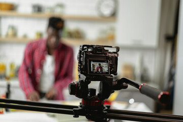 African man filming cooking vlog. Happy man filming his blog about healthy food at home.